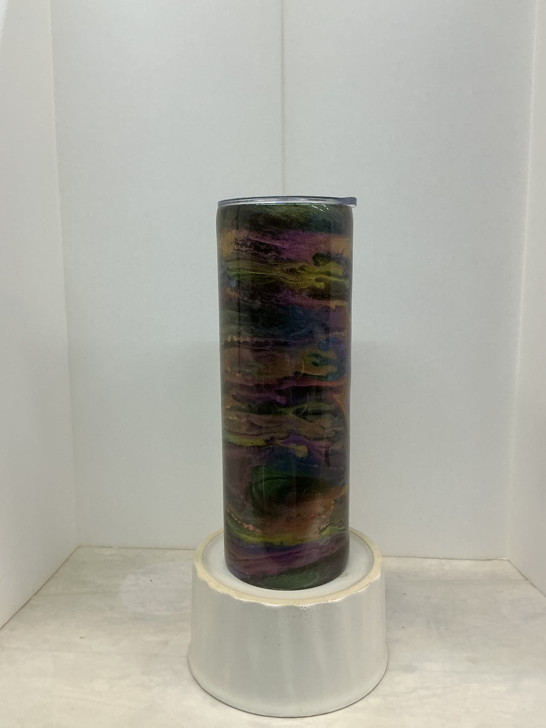 Nancy’s Designs oil slicks with iridescent, rainbow-colored finishes, showcasing vibrant, shiny patterns on a sleek surface.