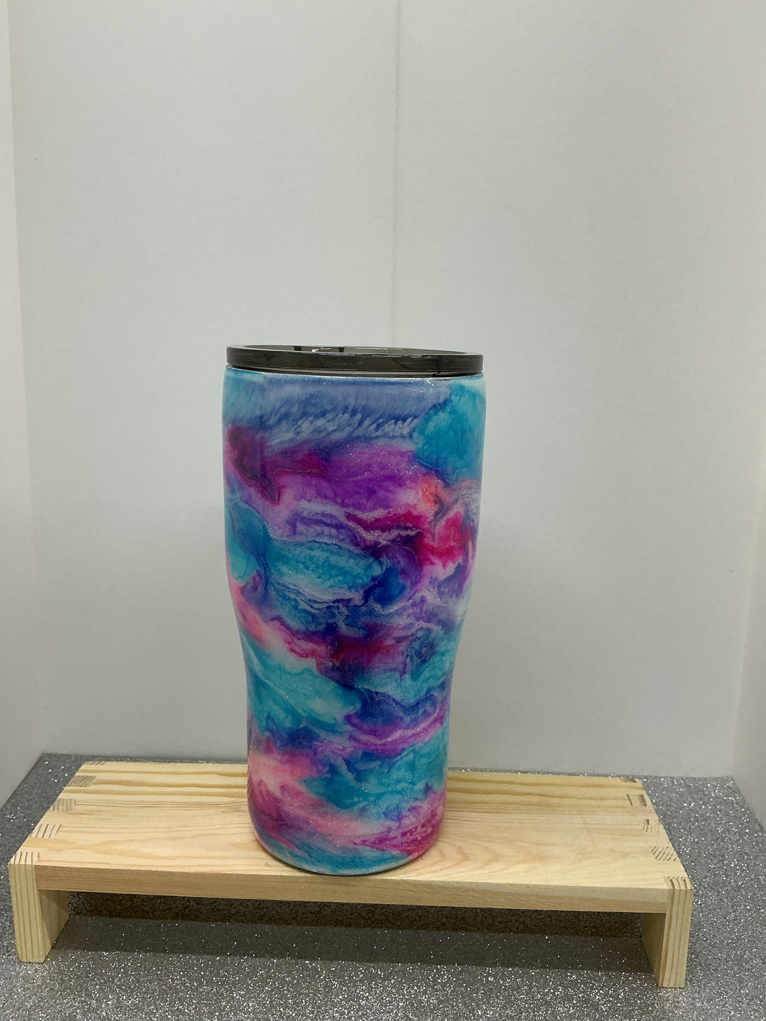 Colorful cotton candy on a stick, made by Nancy’s Designs, with fluffy pink and blue spun sugar on a paper cone.