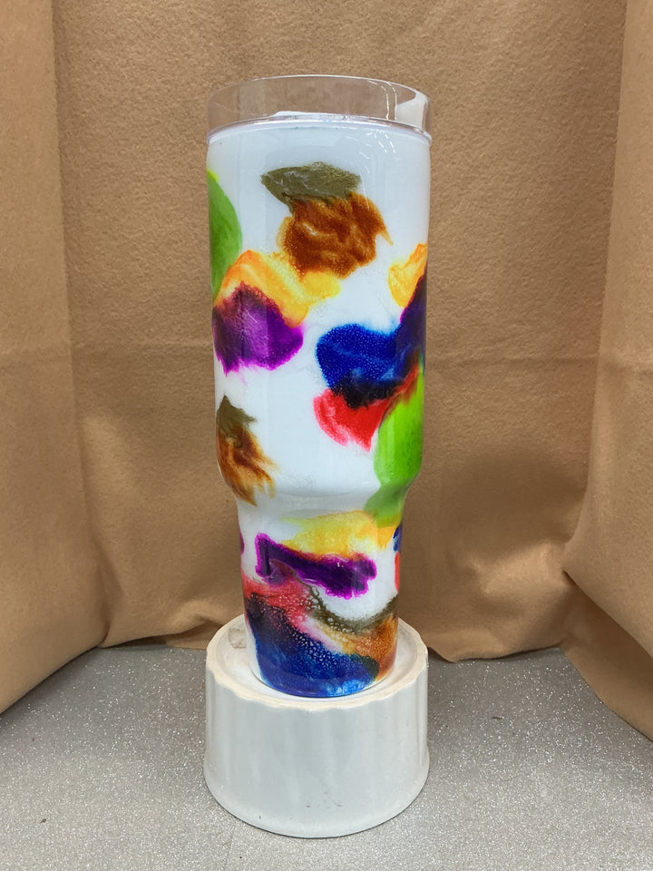 Travel tumbler with colorful abstract design, clear lid, and white base, by Nancy’s Designs.